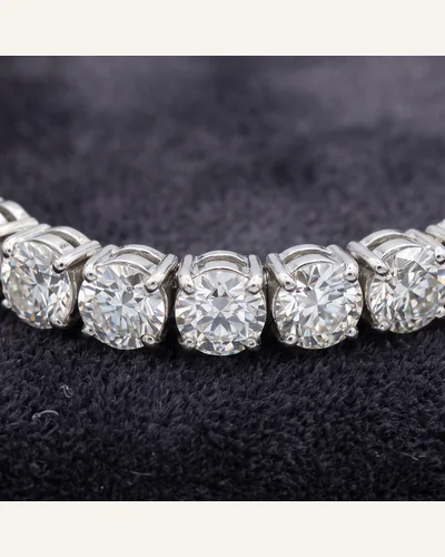 A platinum line bracelet set throughout with graduated round brilliant-cut diamonds, on charcoal velvet. — the setting.
