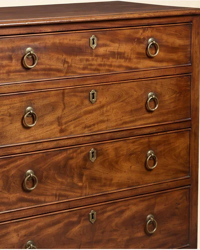 A mahogany serpentine chest of drawers with brass handles, three-quarter view on a paper plate. — the timber.