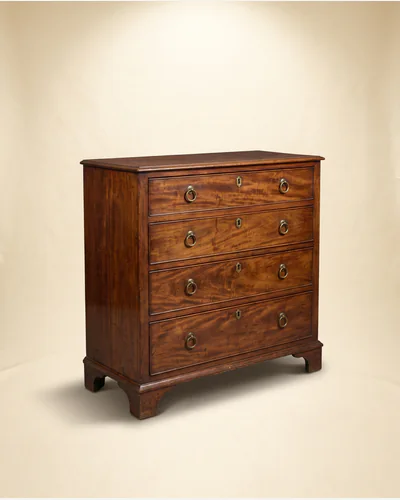 A Georgian mahogany chest of four graduated drawers with brass handles, three-quarter view on a paper plate.