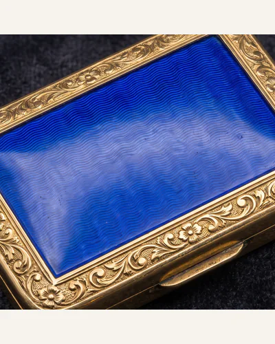 A gold-mounted hardstone snuff box, photographed under macro lighting on charcoal velvet. — the gold mount.