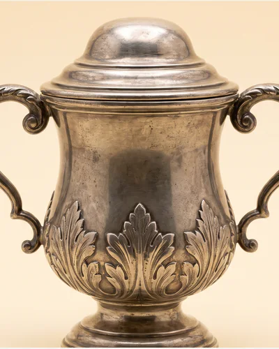 A silver two-handled cup and cover of baluster form with applied cut-card decoration. — the cut-card work.