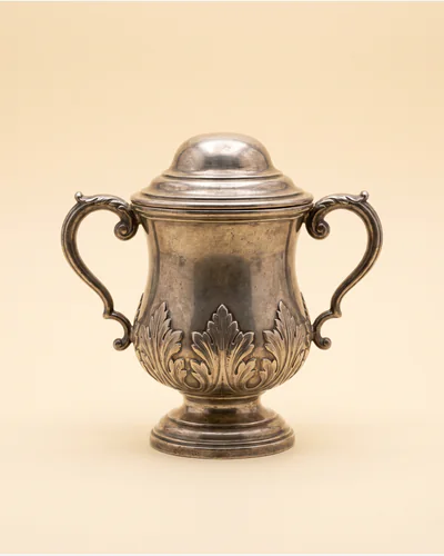 A silver two-handled cup and cover of baluster form with applied cut-card decoration.