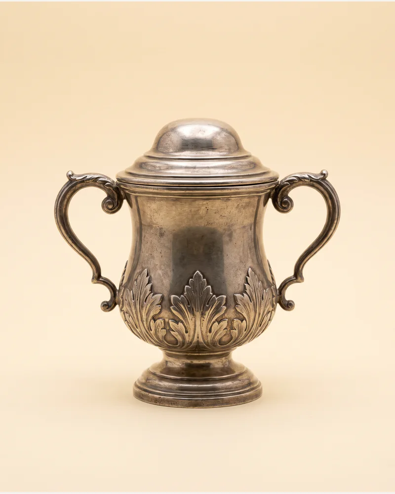 A silver two-handled cup and cover of baluster form with applied cut-card decoration.