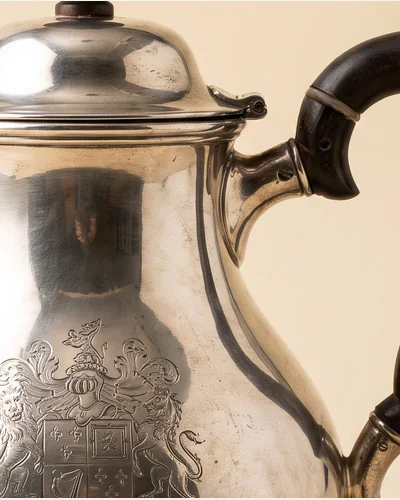 A Georgian sterling silver teapot with a fruitwood handle and an engraved crest. — the handle.