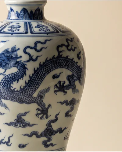 A Chinese blue and white porcelain baluster vase with cobalt dragon decoration, on a warm paper plate. — the glaze.