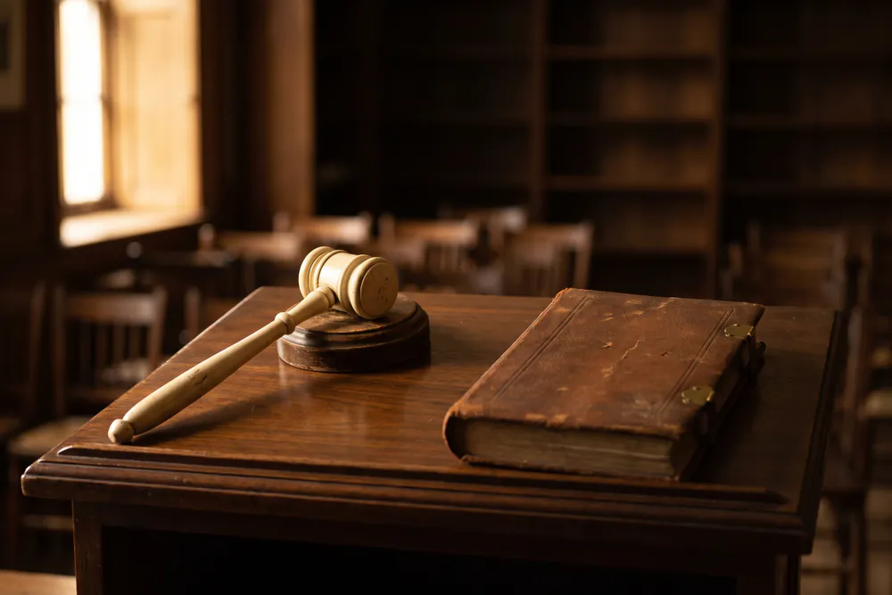 A polished auctioneer's rostrum with a worn gavel resting on its sound block.